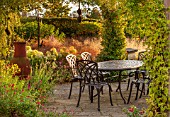 RYE HALL FARM, YORKSHIRE - DESIGNER SARAH MURCH - COUNTRY GARDEN IN AUTUMN, OCTOBER - PERGOLA WITH PATIO, METAL TABLE AND CHAIRS, A PLACE TO SIT, HYDRANGEA ANNABELLE, EATING