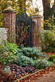 HOLE PARK, KENT: VIEW TO IRON MEMORIAL GATES IN THE FORMAL WALLED GARDEN, COUNTRY GARDEN, CLASSIC, FALL, AUTUMN, OCTOBER