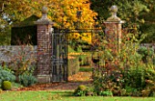 HOLE PARK, KENT: VIEW TO IRON MEMORIAL GATES IN THE FORMAL WALLED GARDEN, COUNTRY GARDEN, CLASSIC, FALL, AUTUMN, OCTOBER