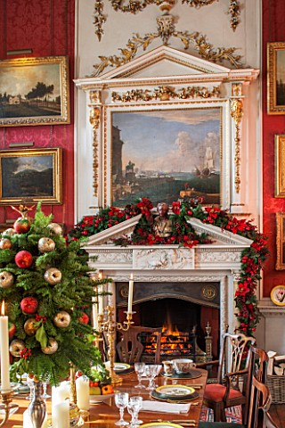 CASTLE_HOWARD_YORKSHIRE_CHRISTMAS__THE_CRIMSON_DINING_ROOM_DECORATED_FOR_CHRISTMAS_WITH_CANDLES_AND_