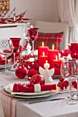 SALTWATER, NORFOLK : DESIGNER KAREN MOORE - CHRISTMAS, DECEMBER, WINTER - THE DINING ROOM IN RED AND WHITE - TABLE, CHAIRS, RIBBONS, DECORATION, LIGHTS, CANDLES, DINNER, WINE GLASS