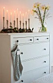SALTWATER, NORFOLK : DESIGNER KAREN MOORE - CHRISTMAS, DECEMBER, WINTER - MASTER BEDROOM IN WHITE AND BLUE - DRESSING TABLE WITH CANDLES AND GLASS CONTAINER WITH WHITE AMARYLLIS