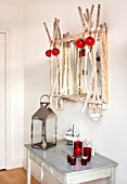 SALTWATER, NORFOLK : DESIGNER KAREN MOORE - CHRISTMAS, DECEMBER, WINTER - BEDROOM IN RED AND WHITE - GREAY TABLE WITH CANDLES AND LANTERN - WOODEN MIRROR - BAUBLES, ORNAMNENT
