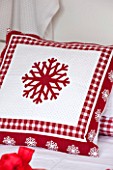 SALTWATER, NORFOLK : DESIGNER KAREN MOORE - CHRISTMAS, DECEMBER, WINTER - BEDROOM IN RED AND WHITE - BED WITH CHRISTMAS PILLOW - ORNAMENT