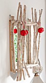 SALTWATER, NORFOLK : DESIGNER KAREN MOORE - CHRISTMAS, DECEMBER, WINTER - BEDROOM IN RED AND WHITE - WOODEN MIRROR WITH RED BAUBLES - ORNAMENT, DECORATION