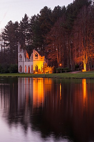PAINSHILL_PARK_SURREY_THE_RUINED_ABBEY_SEEN_ACROSS_THE_LAKE_LIT_UP_AT_NIGHT__LIGHTING_HISTORIC_LAKE_