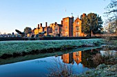 GREAT FOSTERS. SURREY: THE HOTEL ACROSS THE SAXON MOAT IN WINTER - CLIPPED, SHAPED, EVERGREEN, SHRUBS, HEDGES, HEDGING, CLASSIC COUNTRY GARDEN, JANUARY, FROST, FROSTY, FROSTED