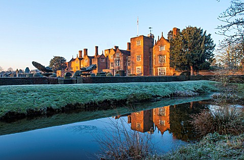 GREAT_FOSTERS_SURREY_THE_HOTEL_ACROSS_THE_SAXON_MOAT_IN_WINTER__CLIPPED_SHAPED_EVERGREEN_SHRUBS_HEDG