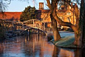 GREAT FOSTERS. SURREY: THE HOTEL AND WOODEN BRIDGE SEEN ACROSS THE SAXON MOAT. WINTER, CLASSIC COUNTRY GARDEN, JANUARY, FROST, FROSTY, FROSTED, DAWN, LAWN, FORMAL