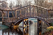 GREAT FOSTERS. SURREY: .THE WOODEN BRIDGE AND SAXON MOAT IN WINTER. CLASSIC COUNTRY GARDEN, JANUARY, FROST, FROSTY, FROSTED, DAWN, FORMAL, FORMAL GARDEN, WATER