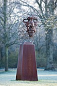 GREAT FOSTERS. SURREY: FIGURE HEAD SCULPTURE BY RICK KIRBY BESIDE THE SAXON MOAT - WATER, ART, CLASSIC, FORMAL, COUNTRY GARDEN, WINTER, FROST, JANUARY