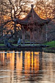 RHS GARDEN, WISLEY, SURREY: THE CHINESE PAGODA BESIDE THE LAKE AT SUNSET - WINTER, JANUARY, CHINA, WATER, POND, EVENING