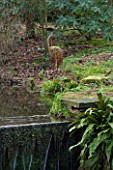 RODE HALL AND GARDENS, CHESHIRE: STEW POND IN WOODLAND WITH WILLOW HERON SCULPTURE. COUNTRY GARDEN, FEBRUARY, WATER, POOL, WATERFALL