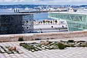 MUCEM, MARSEILLES, FRANCE: THE JARDIN DE MIGRATIONS, FORT SAINT - JEAN. A GARDEN OF STONE SLABS PLANTED BY OLIVIER FILIPPI WITH VIEWS OF MARSEILLES BEYOND. ROOF GARDEN, TERRACE