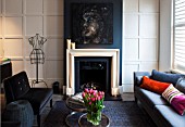 SALLY STOREY HOUSE, LONDON: OPEN PLAN SITTING ROOM / HALL WITH FIREPLACE, PAINTING BY SALLYS DAUGHTER LUCCA, SETTEE, CHAIRS, RUG, LIGHT, CHIMNEY PAINTED IN FARROW & BALL DOWNPIPE