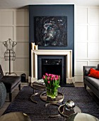 SALLY STOREY HOUSE, LONDON: OPEN PLAN SITTING ROOM / HALL WITH FIREPLACE, PAINTING BY SALLYS DAUGHTER LUCCA, SETTEE, CHAIRS, RUG, LIGHT, CHIMNEY PAINTED IN FARROW & BALLDOWN PIPE