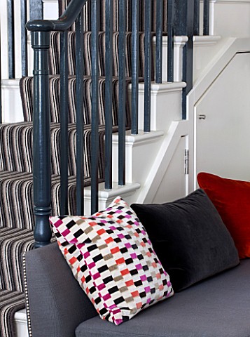 SALLY_STOREY_HOUSE_LONDON_OPEN_PLAN_SITTING_ROOM__HALL_WITH_GREY_CHAIR_WITH_CUSHIONS__BLACK_AND_WHIT