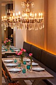 SALLY STOREY HOUSE, LONDON: DINING AREA WITH WOODEN TABLE, DINING CHAIRS, CHANDELIER AND BANQUETTE SEATING, MIRROR, TULIPS. ENTERTAINING, SEAT, SEATS, LIGHTING, LIGHTS
