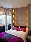 SALLY STOREY HOUSE, LONDON: BEDROOM WITH BED, PINK CUSHIONS, GREY WOODEN PANELING AND GLASS BOTTLES IN RECESSED SHELVES - SHELVING, LIGHT, LIGHTS, LIGHTING