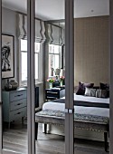 SALLY STOREY HOUSE, LONDON: MASTER BEDROOM WITH BED, CUSHIONS AND SIDEBOARDS REFLECTED IN THE MIRRORED WARDROBE - MIRROR