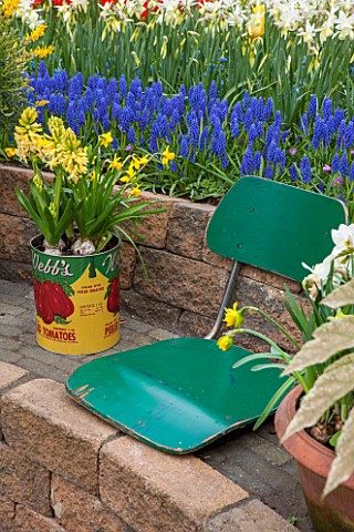 KEUKENHOF_GARDENS_HOLLAND_THE_NETHERLANDS__RECYCLING_GARDEN__STONE_WALL_OLD_GREEN_SEAT_OLD_FOOD_TIN_