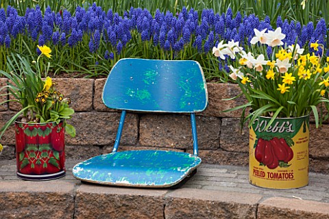 KEUKENHOF_GARDENS_HOLLAND_THE_NETHERLANDS__RECYCLING_GARDEN__STONE_WALL_OLD_BLUE_SEAT_OLD_FOOD_TINS_