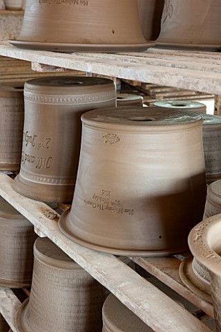 WHICHFORD_POTTERY_WARWICKSHIRE_JUST_MADE_TERRACOTTA_CONTAINERS_DRYING_OUT_ON_WOODEN_RACKS___DECORATI