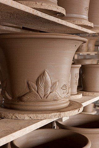 WHICHFORD_POTTERY_WARWICKSHIRE_JUST_MADE_TERRACOTTA_HOSTA_CONTAINERS_DRYING_OUT_ON_WOODEN_RACKS___DE