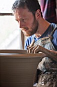 WHICHFORD POTTERY, WARWICKSHIRE: MAN MAKING HAND MADE TERRACOTTA CONTAINER IN WORKSHOP