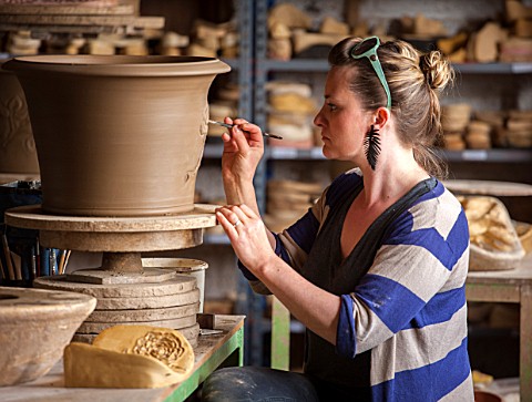 WHICHFORD_POTTERY_WARWICKSHIRE_POTTER_SAS_COOPER_FETTLING_A_TERRACOTTA_CONTAINER_IN_THE_WORKSHOP
