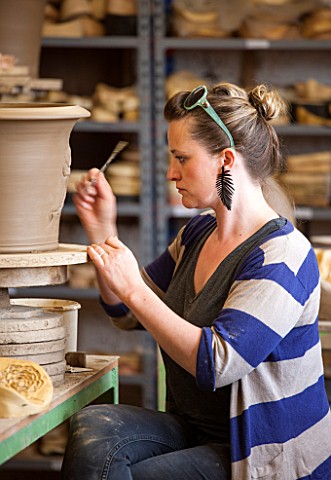 WHICHFORD_POTTERY_WARWICKSHIRE_POTTER_SAS_COOPER_FETTLING_A_TERRACOTTA_CONTAINER_IN_THE_WORKSHOP
