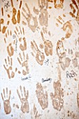 WHICHFORD POTTERY, WARWICKSHIRE: HAND PRINTS OF POTTERS ON THE WALL IN THE WORKSHOP
