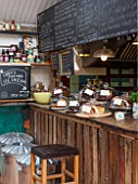 WHICHFORD POTTERY, WARWICKSHIRE: THE CAFE - THE KITCHEN WITH CAKES AND BLACKBOARD WITH MENU