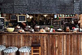 WHICHFORD POTTERY, WARWICKSHIRE: THE CAFE - THE KITCHEN WITH CAKES AND BLACKBOARD WITH MENU