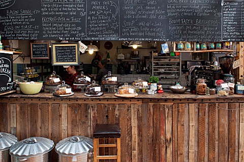 WHICHFORD_POTTERY_WARWICKSHIRE_THE_CAFE__THE_KITCHEN_WITH_CAKES_AND_BLACKBOARD_WITH_MENU