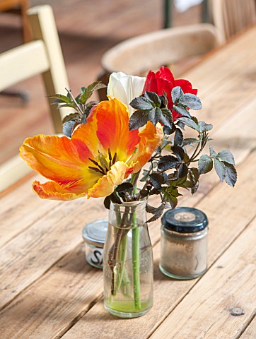WHICHFORD_POTTERY_WARWICKSHIRE_THE_CAFE__WOODEN_TABLE_AND_CHAIRS_WITH_GLASS_VASE__FILLED_WITH_FLOWER