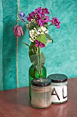 WHICHFORD POTTERY, WARWICKSHIRE: THE CAFE - WOODEN TABLE WITH GLASS VASES FILLED WITH FLOWERS - PURPLE WALLFLOWERS AND SNAKES HEAD FRITILLARY - FRITILLARIA MELEAGRIS
