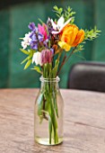 WHICHFORD POTTERY, WARWICKSHIRE: THE CAFE - WOODEN TABLE WITH GLASS VASE FILLED WITH FLOWERS - ORANGE TULIP, SNAKES HEAD FRITILLARY AND BLUEBELLS