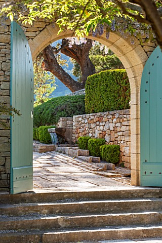 LA_JEG_PROVENCE_FRANCE_STONE_STEPS_BLUE_WOODEN_GATES_STONE_WALL_RILL_FOUNTAIN_BOX_HEDGING__BUXUS_CLI