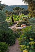 LA JEG, PROVENCE, FRANCE: DESIGNER ANTHONY PAUL - PATH WITH CERAMIC SEATS BY HANNAH BENNET. SPRING. MEDITERRANEAN, GARDEN, GREEN, PROVENCE, MAY, SCULPTURE, EUPHORBIA