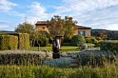 JEG, PROVENCE, FRANCE: DESIGN: ANTHONY PAUL - THE HOUSE WITH BLUE SHUTTERS. CLIPPED PLANTS BESIDE LAWN, SCULPTURE LOVERS BY MARZIA COLONNA. SUMMER,  COUNTRY, GARDEN