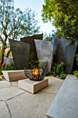 CHELSEA FLOWER SHOW 2016: TELEGRAPH GAREDEN DESIGNED BY ANDY STURGEON - LIMESTONE PATIO AND BRONZE FINS, LIMESTONE SEATS AND FIREPIT - SEATING, BENCH, BENCHES, FIRE, TERRACE