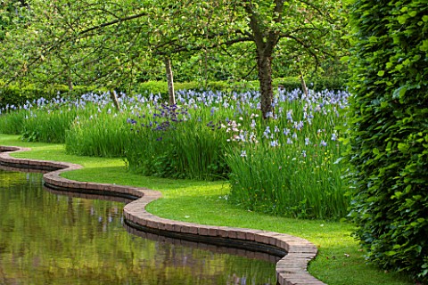 BRYANS_GROUND_HEREFORDSHIRE_THE_SERPENTINE_CANAL_AND_ORCHARD_IN_LATE_SPRING_WITH_APPLE_TREES__BLUE_F