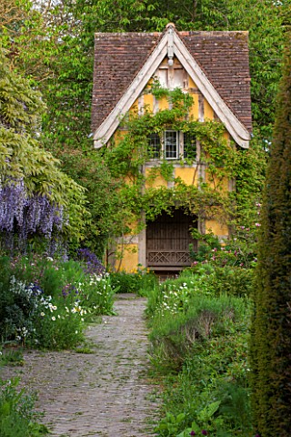 BRYANS_GROUND_HEREFORDSHIRE_THE_TERRACE_BEHIND_THE_HOUSE_WITH_WISTERIA_AND_VIEW_TO_DOVECOTE_DESIGNED