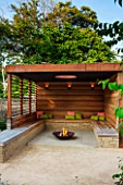 PRIVATE GARDEN LONDON DESIGNED BY LUCY WILLCOX AND ANA SANCHEZ MARTIN:FIRE PIT, PERGOLA WITH WOODEN BENCH SEATING, CUSHIONS, COVERED SEATING AREA, WALL, RELAXING