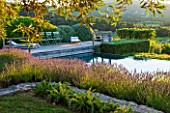 LA JEG, PROVENCE, FRANCE: DESIGNER ANTHONY PAUL - VIEW OF LAVENDER - LAVENDULA GROSSO -  AND SWIMMING POOL WITH COUNTRYSIDE BEYOND. LAVENDULA, PURPLE, WATER, POOL, SEEATS, SEATING