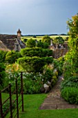 GREYHOUNDS, BURFORD, OXFORDSHIRE: VIEW TO PATH AND BORDERS WITH COTTAGE STYLE INFORMAL PLANTING. WINTER CLOCHES ON DRY STONE WALL AND YEW TOPIARY. SUMMER GARDEN