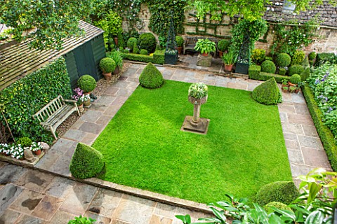 RADFORDS_BURFORDOVERVIEW_OF_SMALL_FORMAL_GARDEN_WITH_LAWN_AND_BOX_PYRAMIDS_AND_BALLSBACK_WALL_TRAINE
