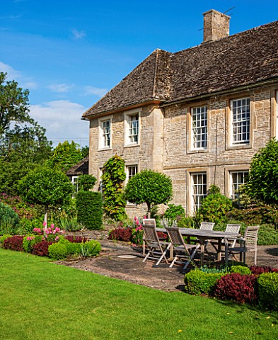 OXLEAZE_FARM_HOUSEOXFORDSHIREFRONT_OF_HOUSE__GARDEN_TERRACE_WITH_FORMAL_PLANTING_OF_PRUNUS_LUSITANIC