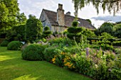 GREYHOUNDS, BURFORD, OXFORDSHIRE: THE CROQUET LAWN BORDER WITH HORNBEAM SCREEN AND YEW AND BOX TOPIARY. CLASSIC COUNTRY GARDEN, SUMMER